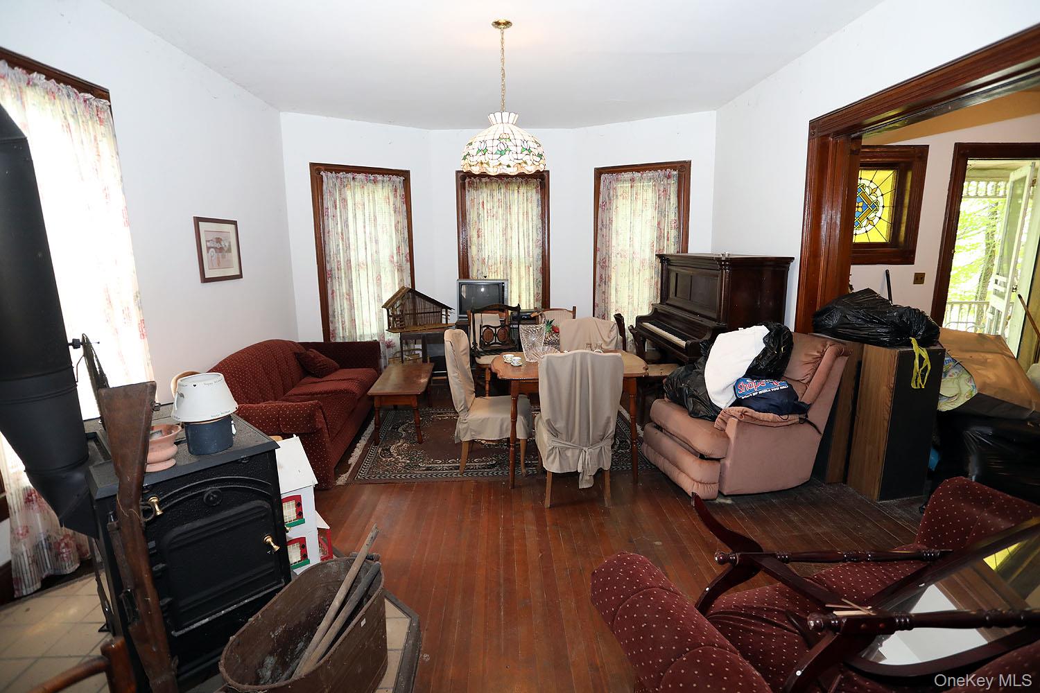 50 Parsonage Road Cochecton, NY 12726 - Photo 6 of 21 Living room featuring wood floors, wood stove and floor-to-ceiling windows