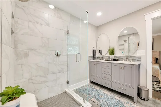 a bathroom with a double vanity sink mirror and shower