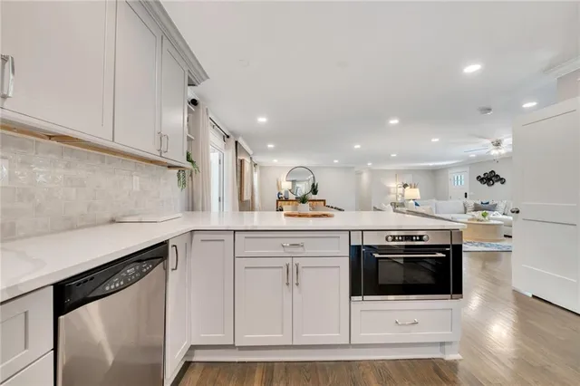a kitchen with stainless steel appliances granite countertop a stove a sink and a microwave