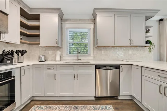a kitchen with stainless steel appliances granite countertop a sink a stove and a microwave