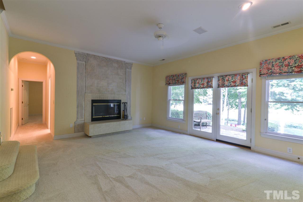 7608 Kelmscot Way Raleigh, NC 27615 - Photo 17 of 23 a view of an empty room with a fireplace and a window
