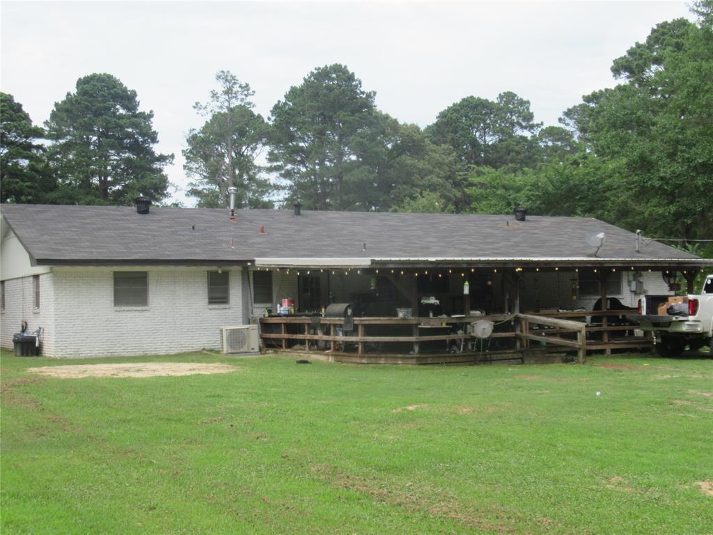 24133 Highway 157 Springhill, LA 71075 - Photo 8 of 19 Spacious backyard with a covered deck, wood deck railing, and a ramp for ease of access