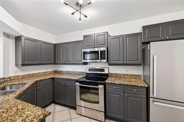 a kitchen with granite countertop a refrigerator stove and microwave