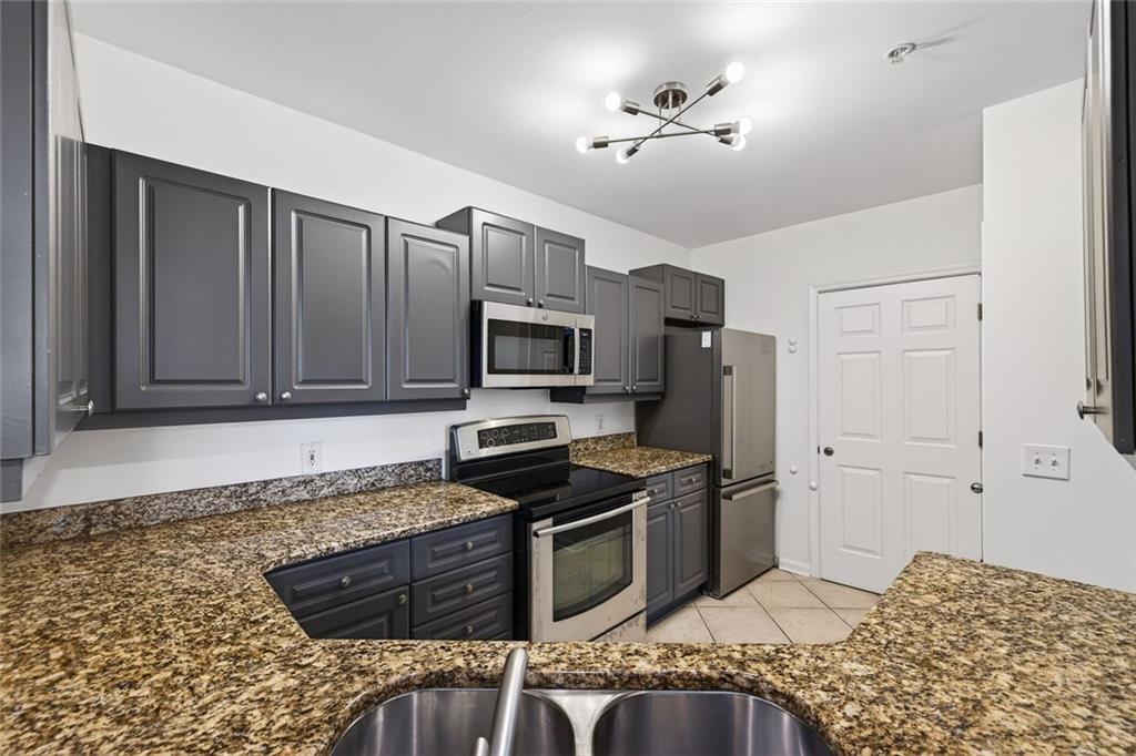3334 Peachtree Road Northeast, Unit 905 Atlanta, GA 30326 - Photo 10 of 29 a kitchen with stainless steel appliances granite countertop a stove a sink and a microwave
