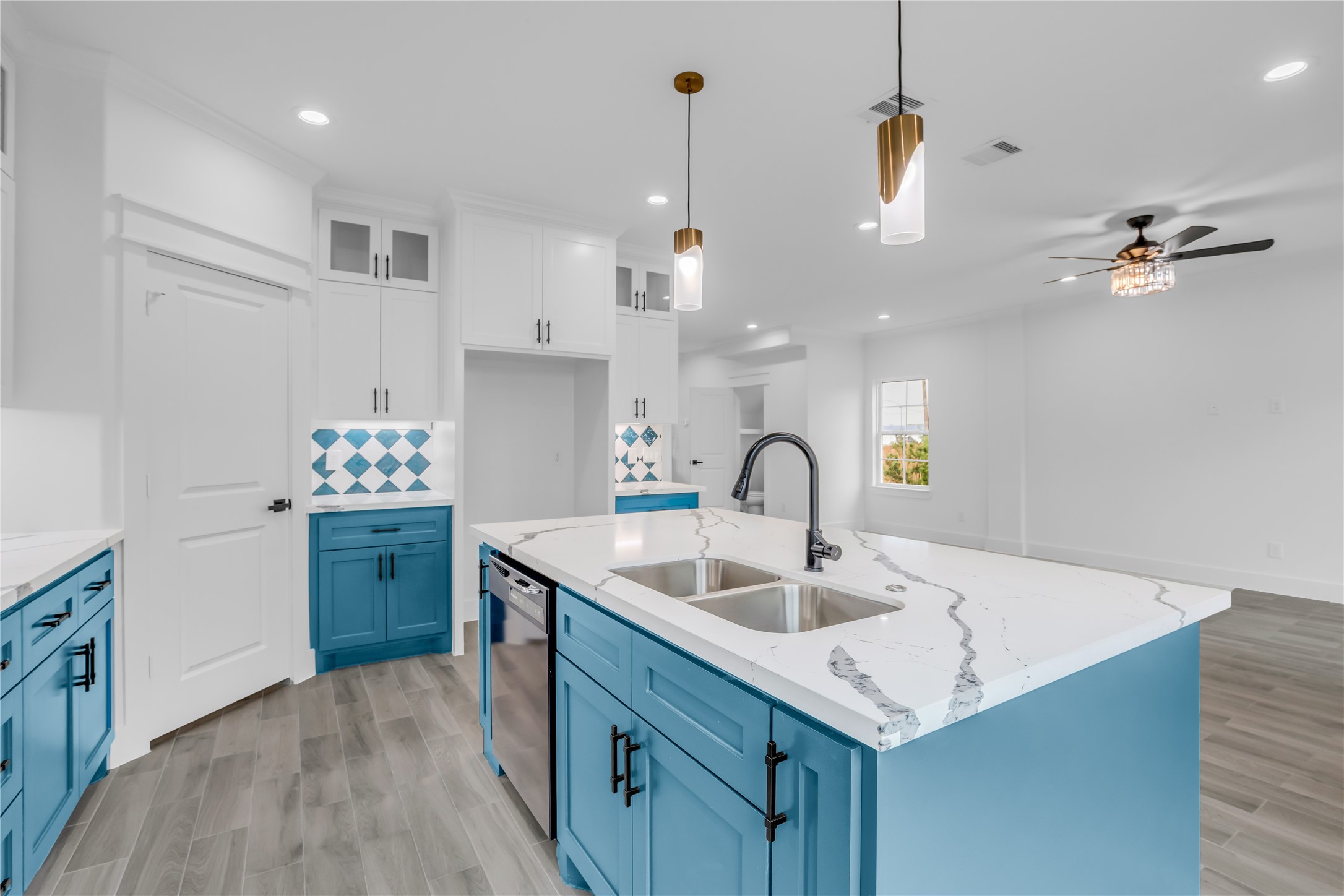 3168 Golfcrest Houston, TX 77087 - Photo 24 of 36 This kitchen offers a modern oasis with vibrant blue cabinetry, sleek marble countertops, and upscale fixtures, perfect for culinary creativity and stylish entertaining.