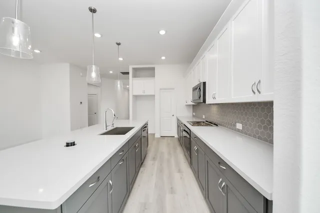 a kitchen with kitchen island a sink a stove and a refrigerator