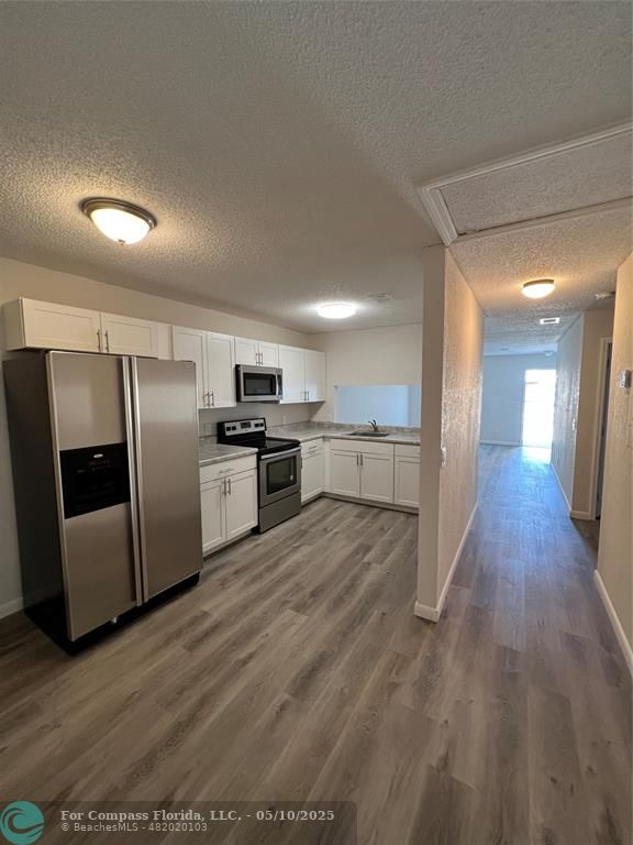 312 Carissa Drive Pahokee, FL 33476 - Photo 11 of 14 a kitchen with stainless steel appliances granite countertop a refrigerator a sink a stove and oven