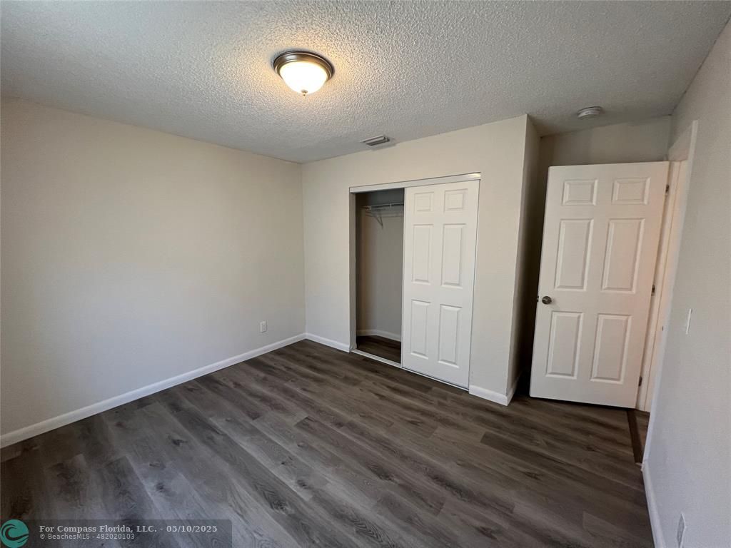 312 Carissa Drive Pahokee, FL 33476 - Photo 8 of 14 a view of an empty room with wooden floor