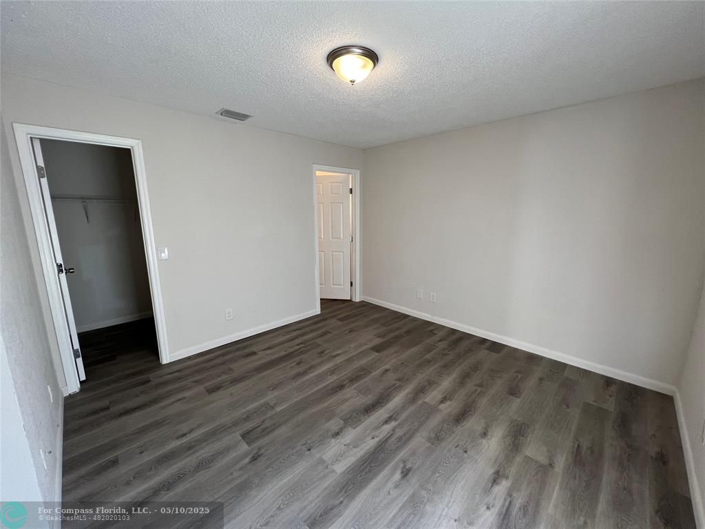 312 Carissa Drive Pahokee, FL 33476 - Photo 9 of 14 an empty room with wooden floor and windows