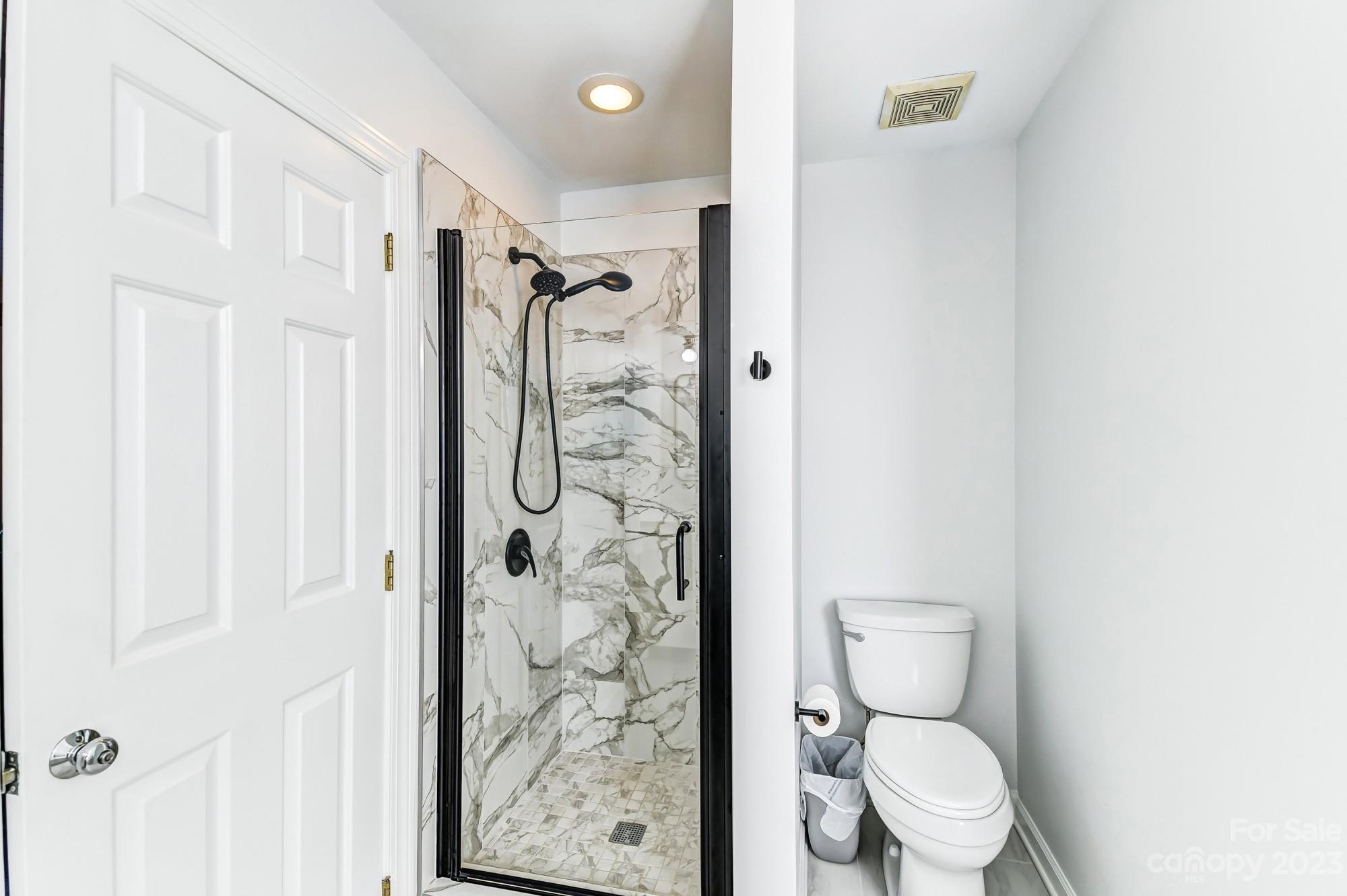 1663 Heather Glen Road Kannapolis, NC 28081 - Photo 23 of 40 a white toilet sitting next to a shower curtain