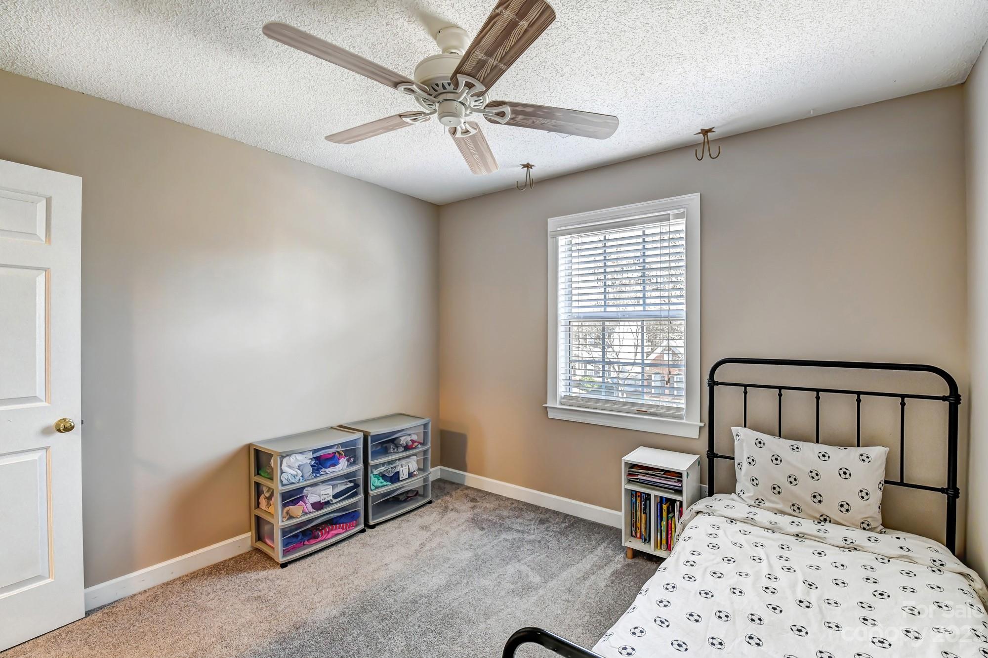 1663 Heather Glen Road Kannapolis, NC 28081 - Photo 26 of 40 a bedroom with a bed a chandelier and a window
