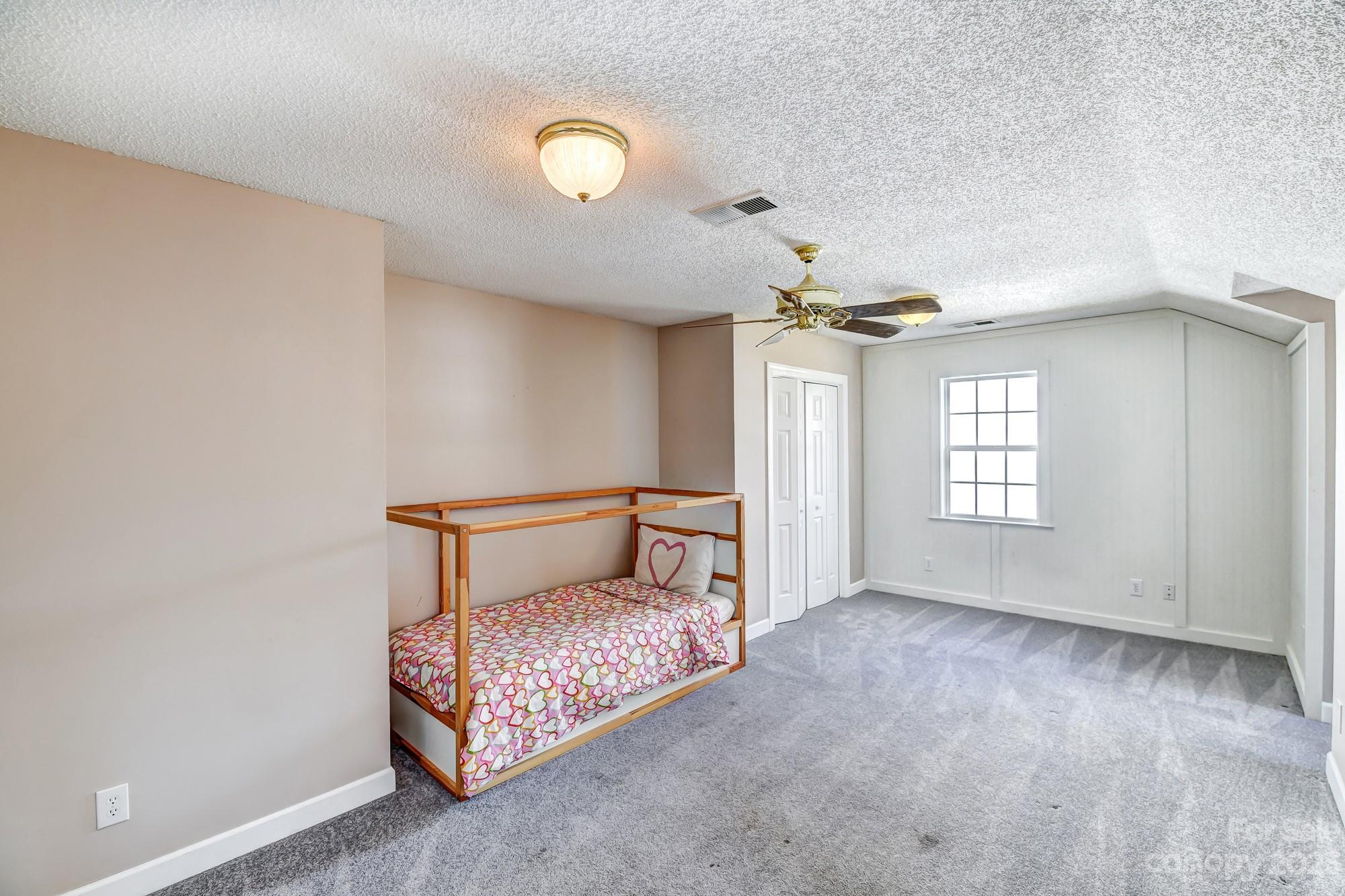 1663 Heather Glen Road Kannapolis, NC 28081 - Photo 31 of 40 a room with a bed and a chandelier
