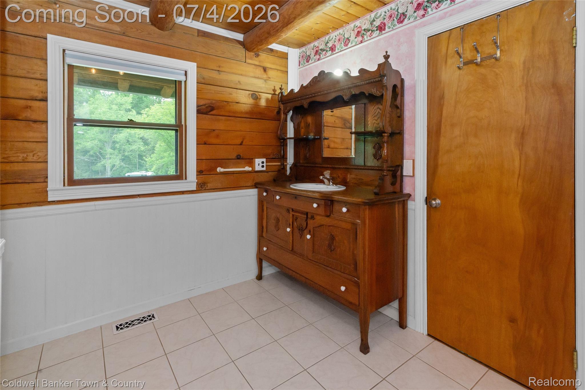 7335 Richardson Road Howell, MI 48843 - Photo 30 of 54 Rustic bathroom featuring a wood-panel accent wall, white wainscoting, and a decorative vanity with an integrated sink