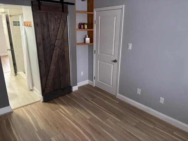 a view of a room with wooden floor and a window