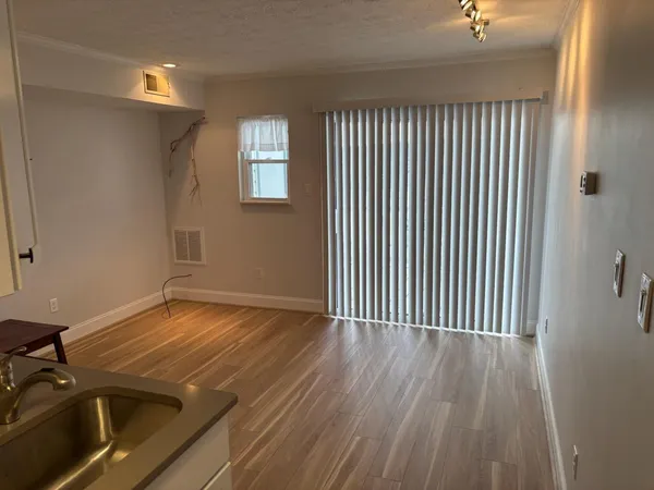 a view of a room with wooden floor and window