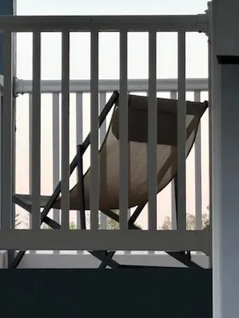 a front view of a house with two chairs and a table