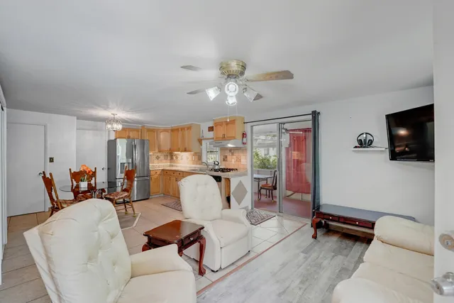 a living room with furniture a flat screen tv and a window