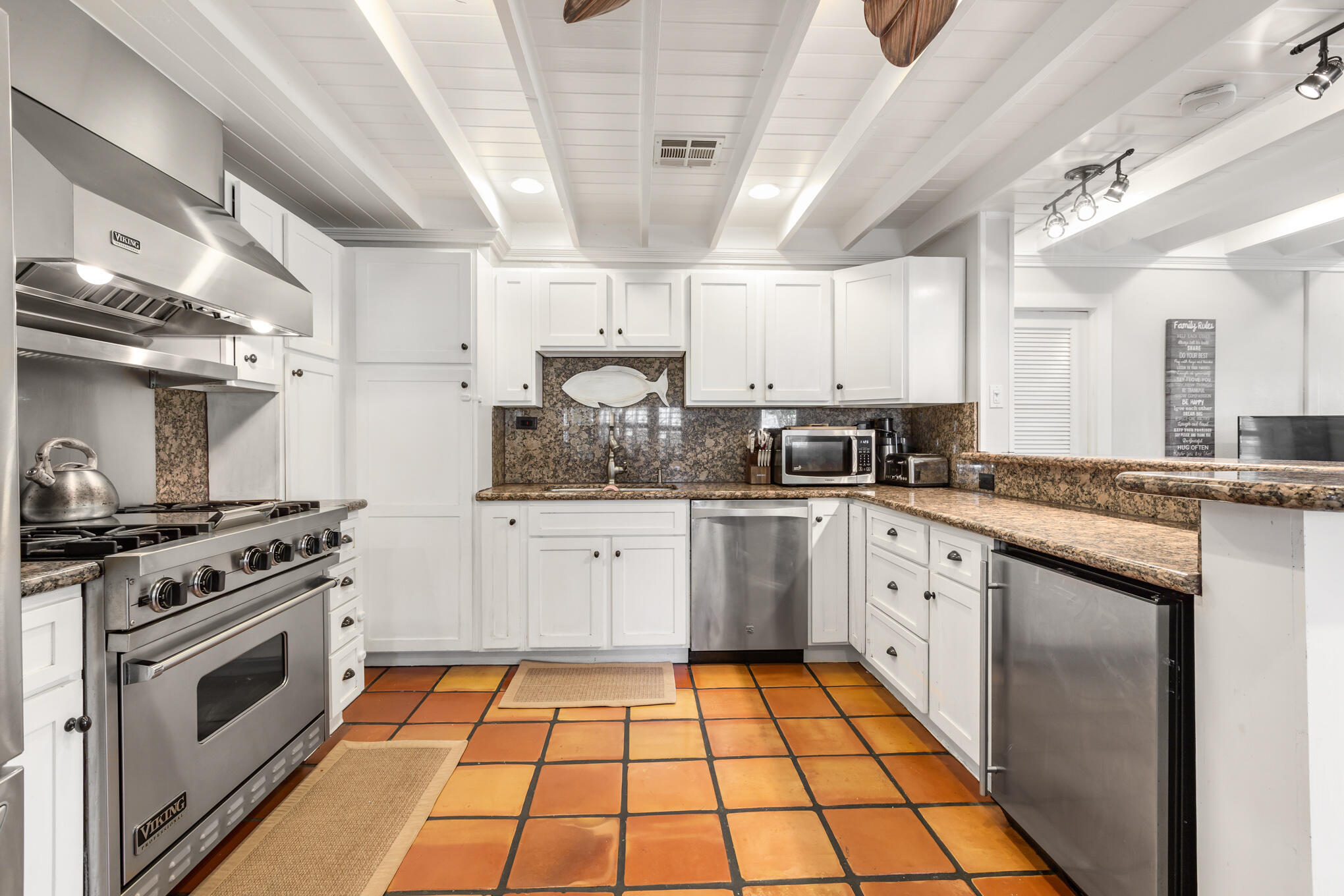 a kitchen with stainless steel appliances granite countertop a stove and white cabinets