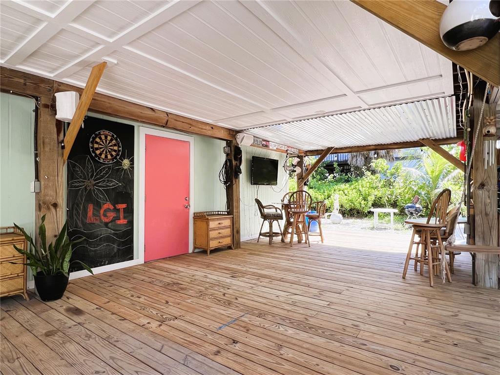 8662 Grand Avenue Boca Grande, FL 33921 - Photo 16 of 63 a view of a patio with table and chairs with wooden floor and fence