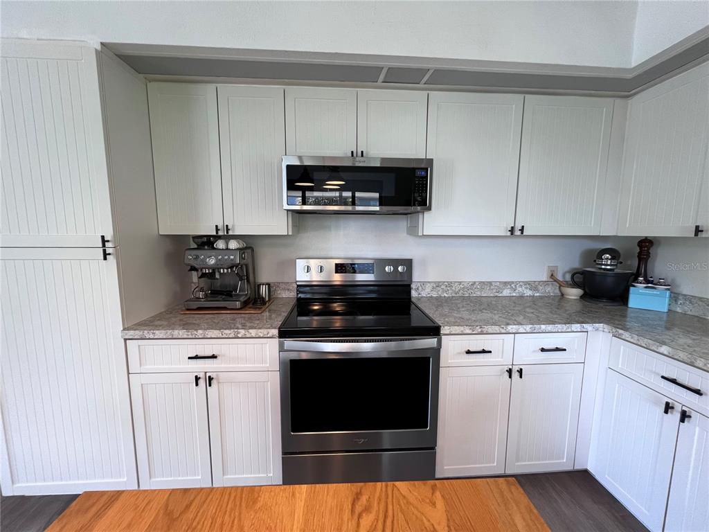 8662 Grand Avenue Boca Grande, FL 33921 - Photo 32 of 63 a kitchen with stainless steel appliances granite countertop a stove a microwave and cabinets