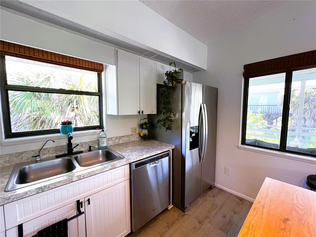 8662 Grand Avenue Boca Grande, FL 33921 - Photo 38 of 68 a kitchen with stainless steel appliances a sink a refrigerator a window and cabinets