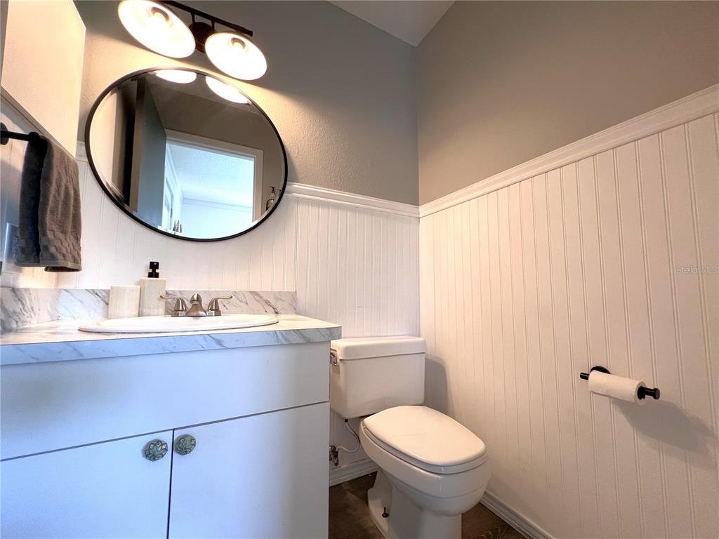 8662 Grand Avenue Boca Grande, FL 33921 - Photo 44 of 63 a bathroom with a granite countertop toilet sink mirror and vanity