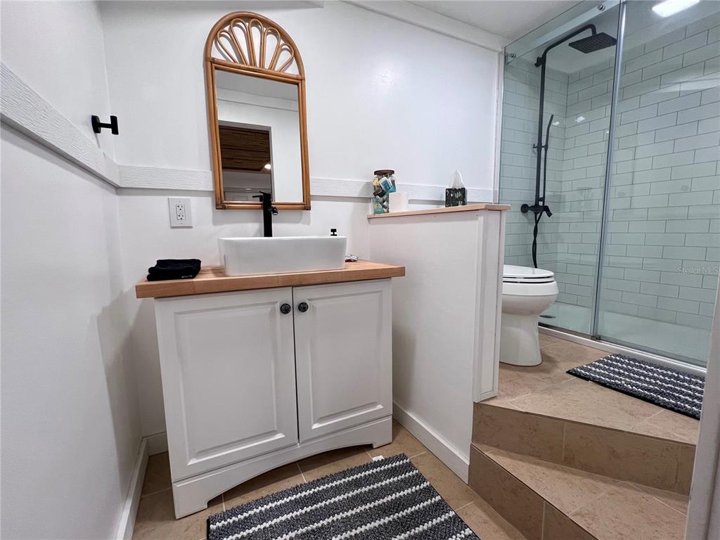 8662 Grand Avenue Boca Grande, FL 33921 - Photo 52 of 63 a bathroom with a sink a toilet a mirror and shower