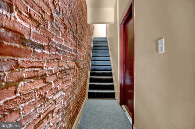a view of a hallway with stairs and wooden floor