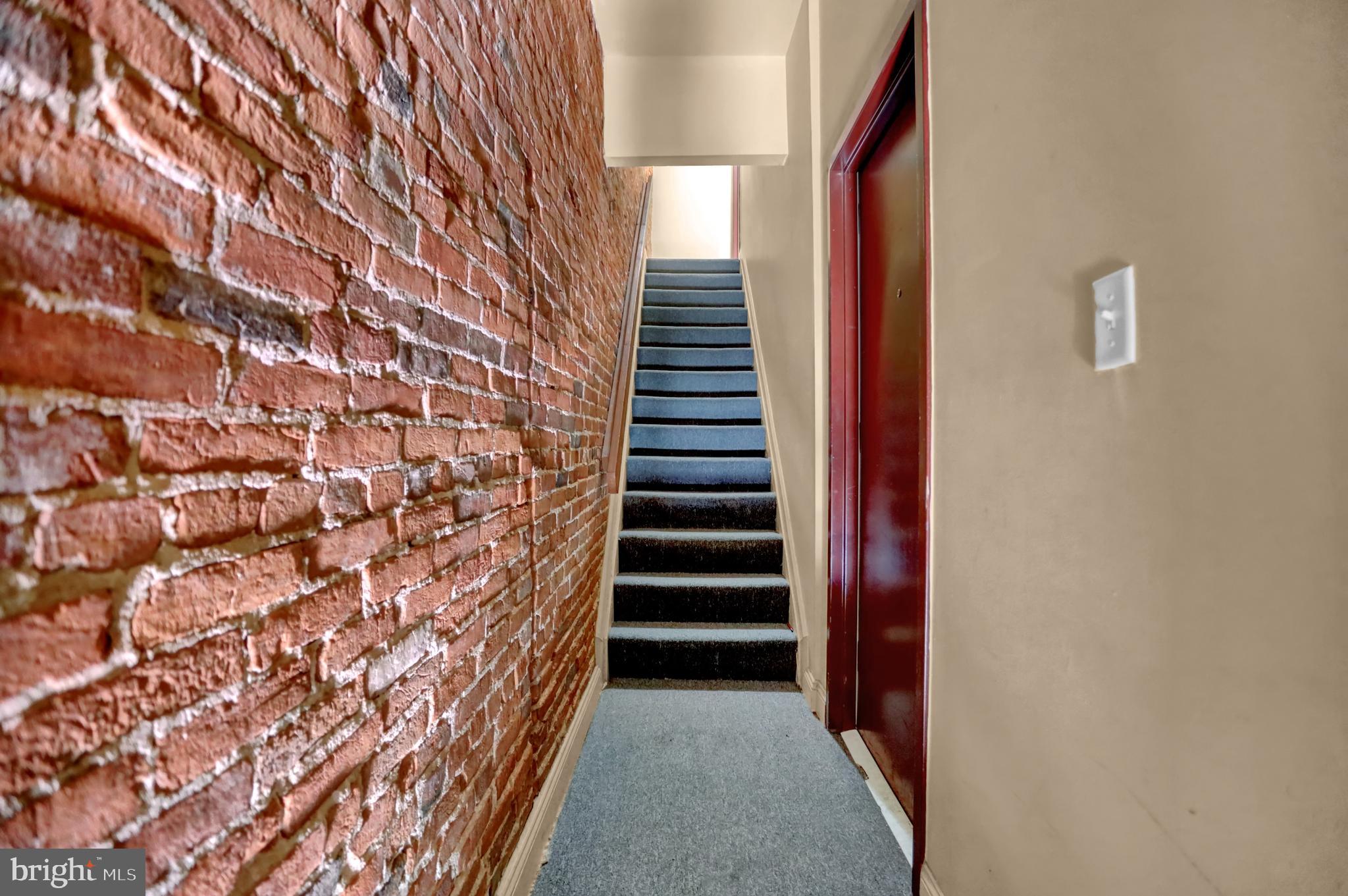 1103 Light Street, Unit A Baltimore, MD 21230 - Photo 7 of 23 a view of a hallway with stairs and wooden floor