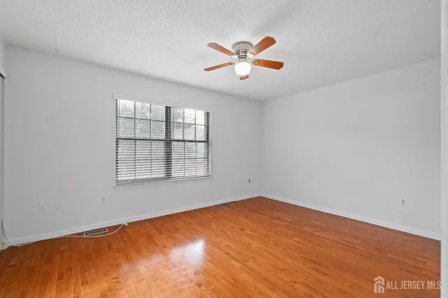 an empty room with a window and ceiling fan
