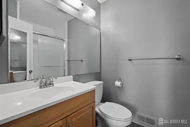 a bathroom with a sink a toilet a shower and a mirror