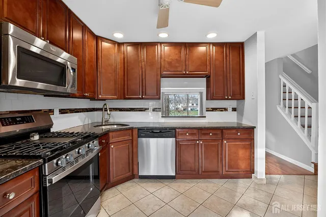a kitchen with stainless steel appliances wooden cabinets and a stove top oven
