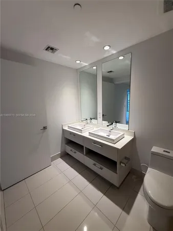 a bathroom with a sink a toilet a mirror and vanity