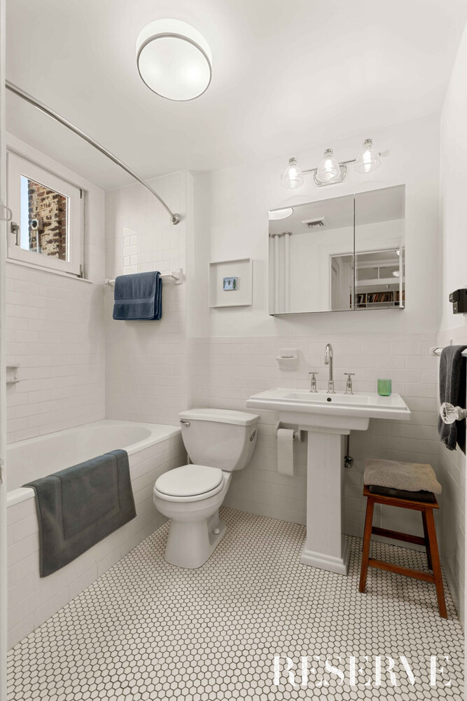 29 Perry Street, Unit 5R Manhattan, NY 10014 - Photo 12 of 14 a bathroom with a sink toilet a mirror and vanity