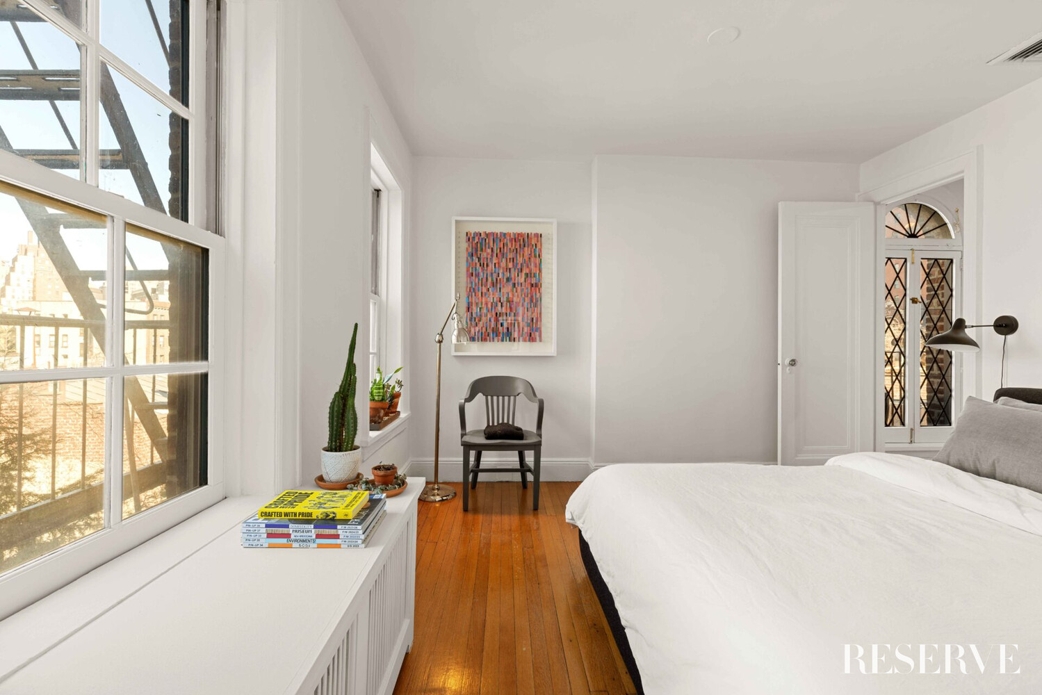 29 Perry Street, Unit 5R Manhattan, NY 10014 - Photo 8 of 14 a bedroom with a bed and a window with wooden floor