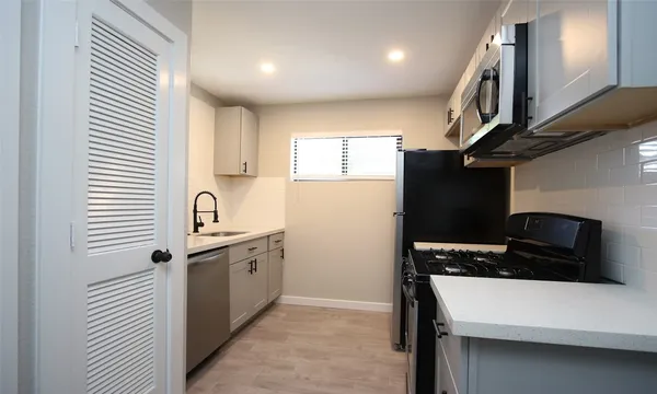 a kitchen with a refrigerator and a stove top oven