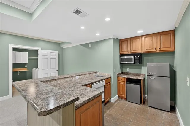 a kitchen with stainless steel appliances granite countertop a refrigerator and a sink