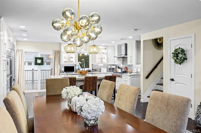 a living room with furniture kitchen view and a chandelier