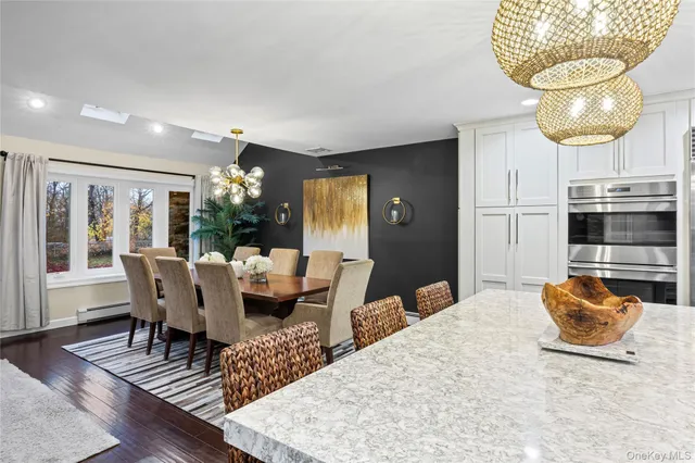 a living room with furniture a chandelier and wooden floor