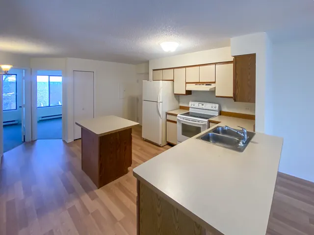 a kitchen with sink a refrigerator and wooden floor