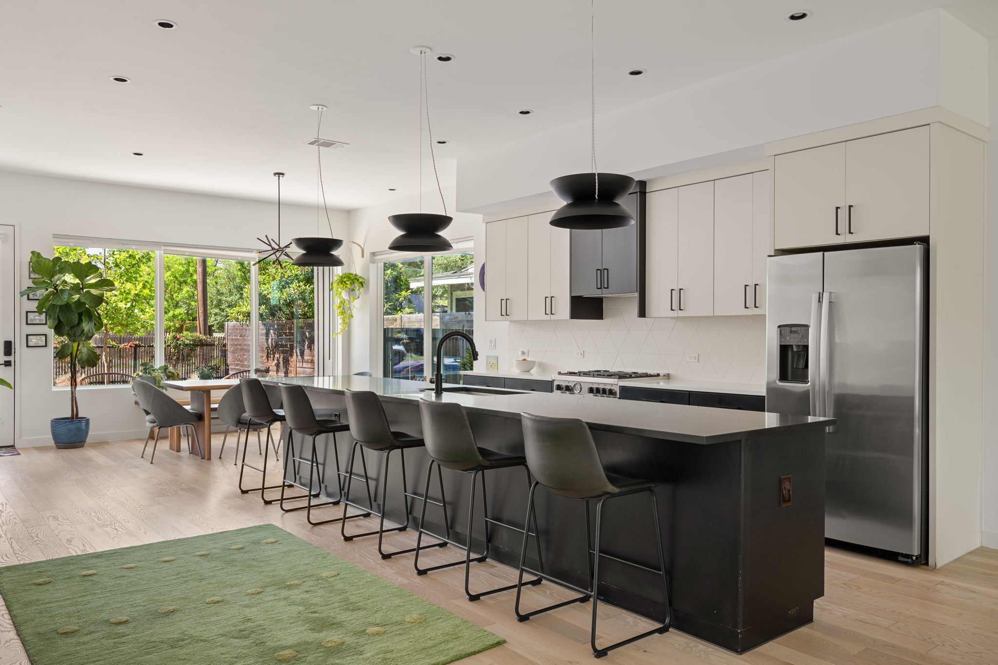 a kitchen with stainless steel appliances granite countertop a stove and a view of living room
