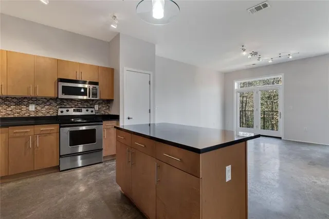 a kitchen with kitchen island a stove and a sink