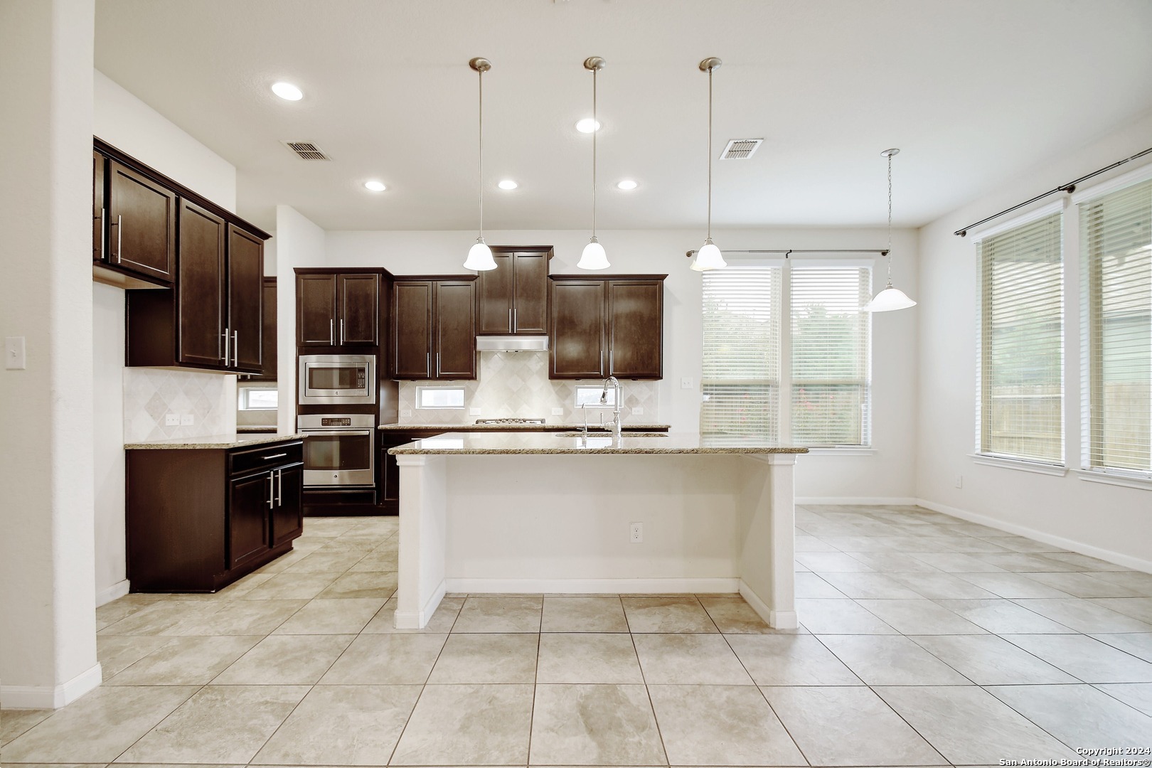 a large kitchen with kitchen island granite countertop a large counter top stainless steel appliances and cabinets