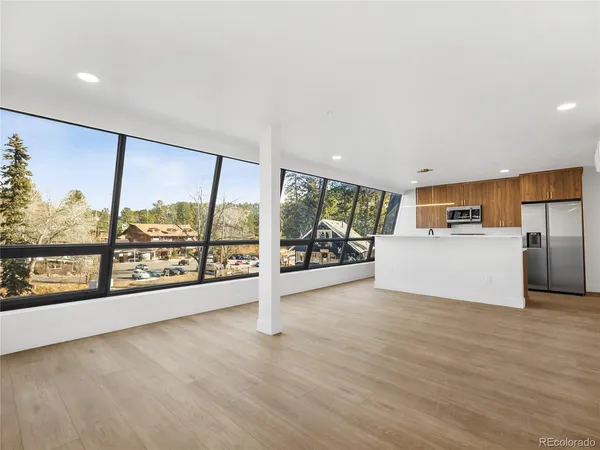 a view of a living room hardwood floor and a large window