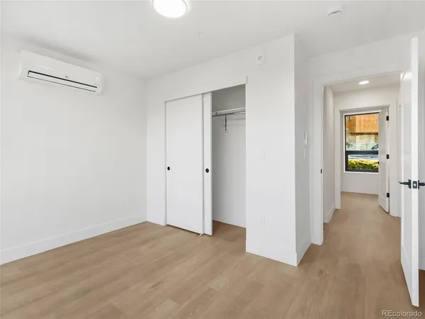 a view of a hallway with wooden floor and closet