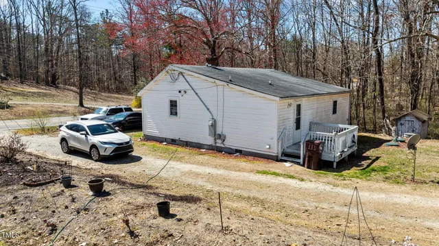 a white house covered with tall trees