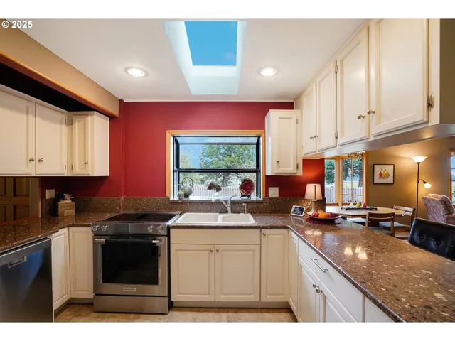 a kitchen with stainless steel appliances granite countertop a sink stove and cabinets