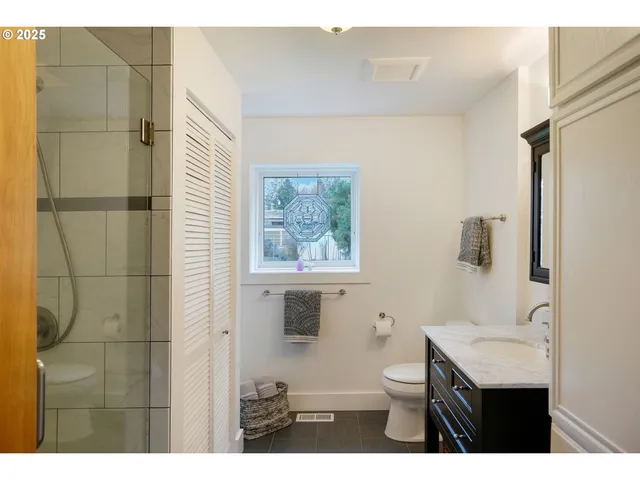 a bathroom with a toilet a sink and mirror