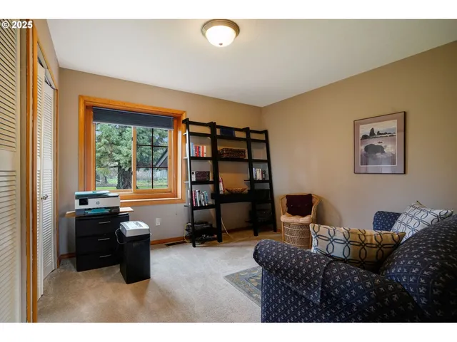 a living room with furniture a large window and bookshelf