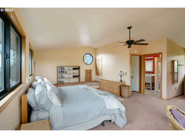 a bedroom with a bed and a large mirror on the dresser